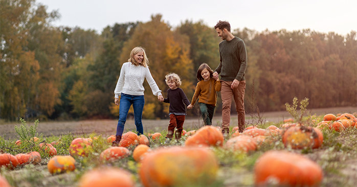 Family walking together through pumpkin patch.